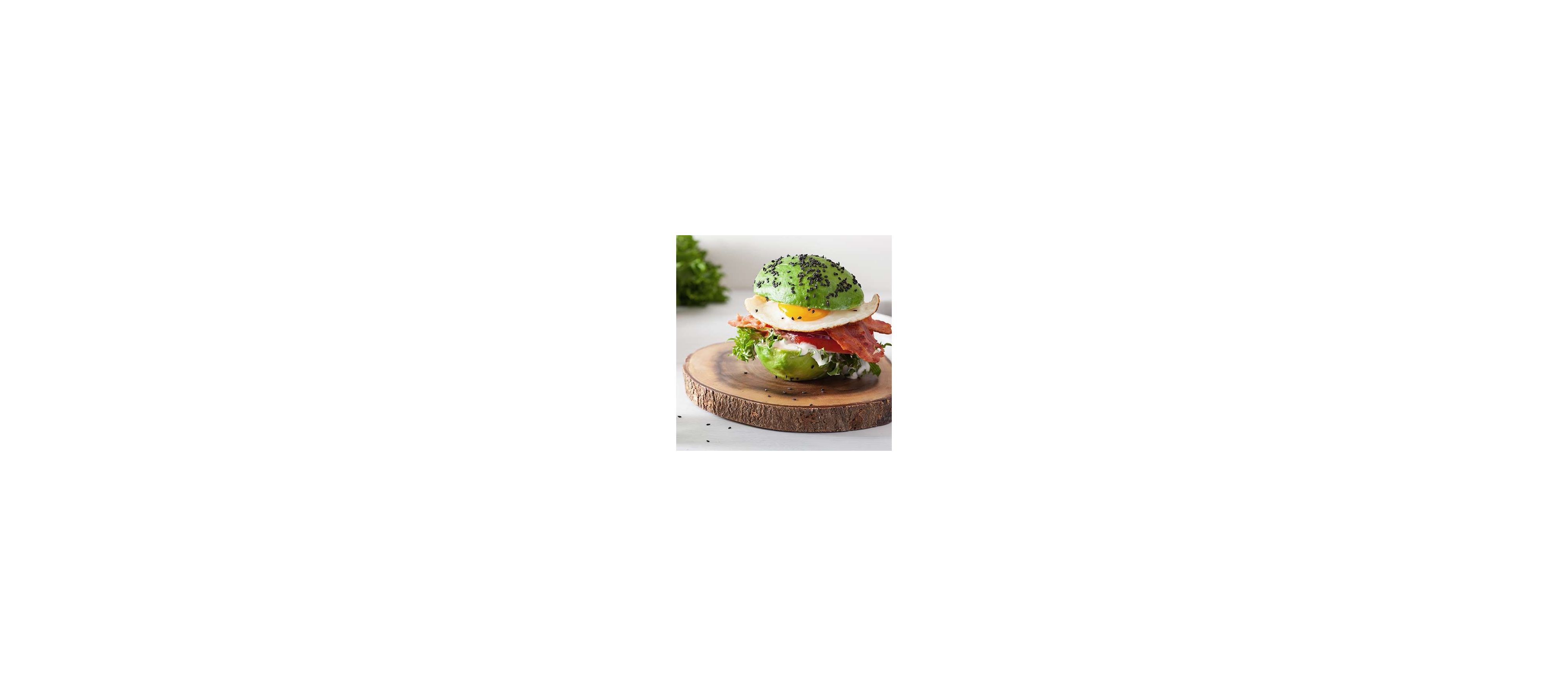 Avocado served as a sandwich, cut in the middle with egg, bacon and lettuce between the avocado halves