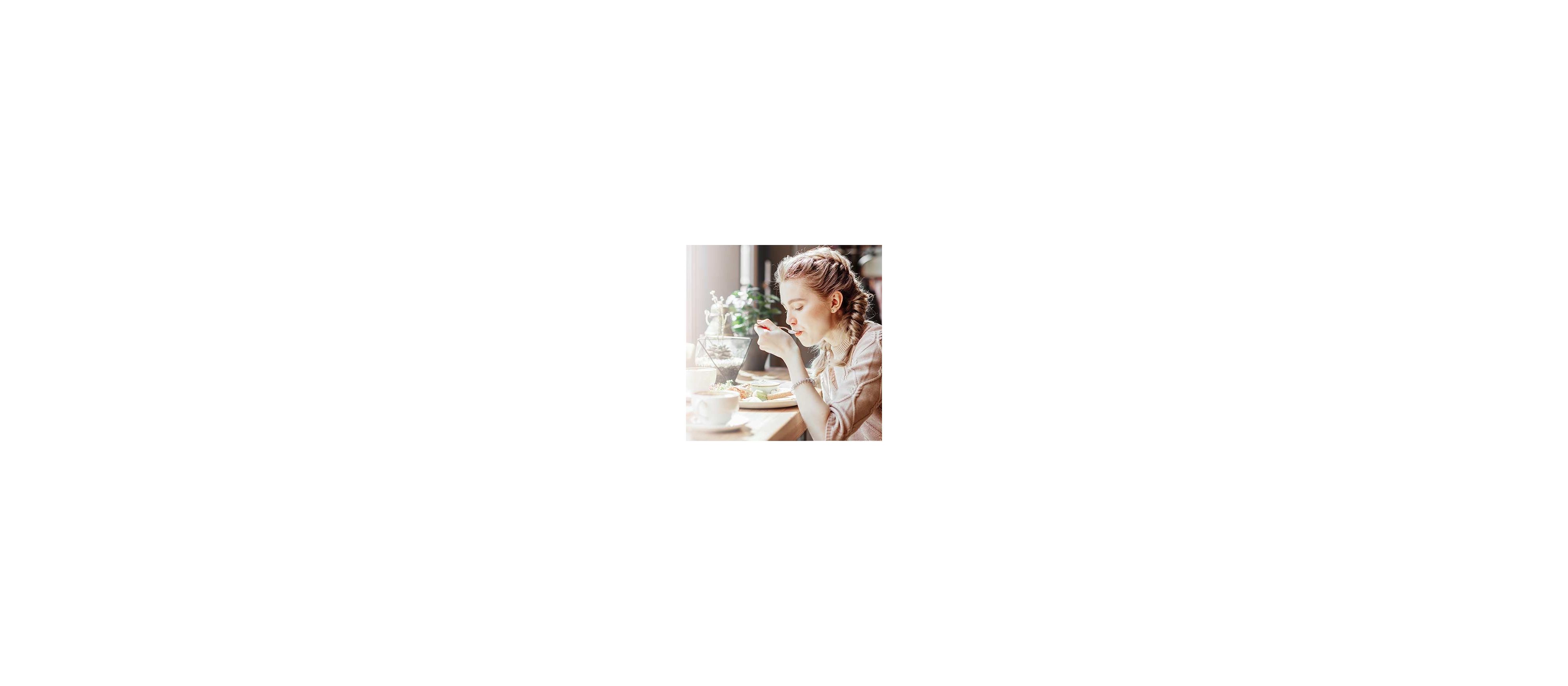 Woman sits in a cafe and eats lunch