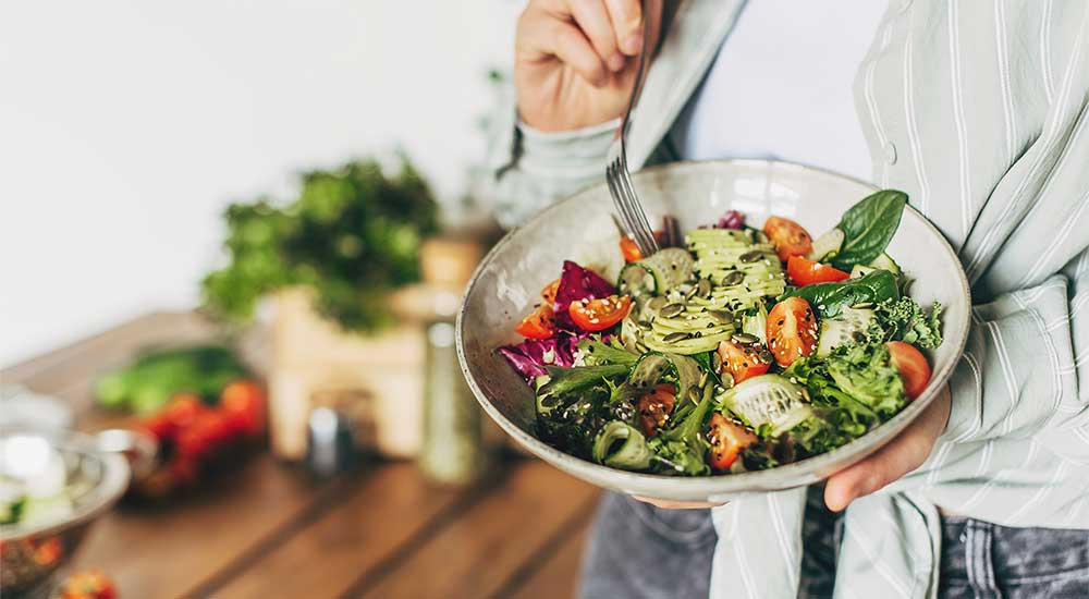 Woman holding a plate filled with vegetables
