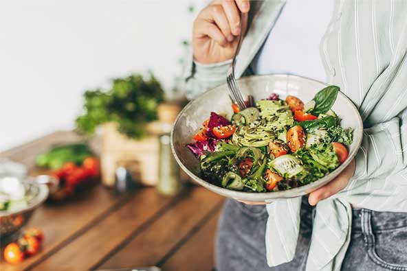 Woman holding a plate filled with vegetables