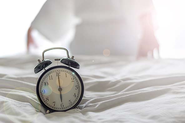 Väckarklocka som står på 06.00 i morgonljus