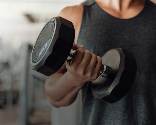 Hand lifting a heavy dumbbell for strength training