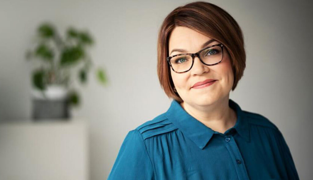 Profiilikuva Johanna Abgottsponista, jolla on lyhyet, tummat hiukset ja harmaa tausta.